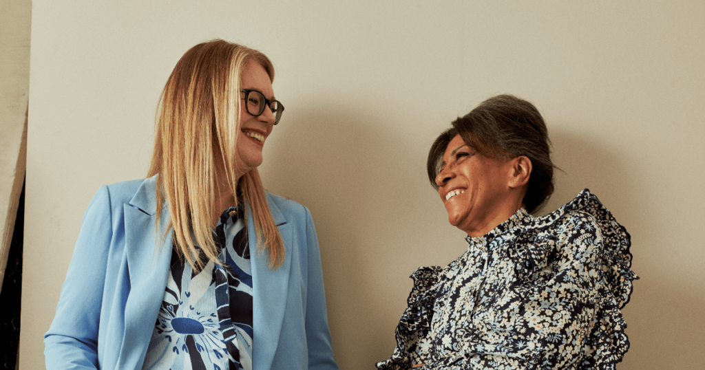 Two women looking at each other smiling and laughing